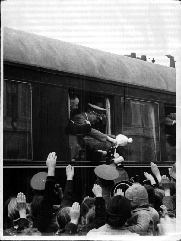 Adolf Hitler in his train greets people at Salzburg station